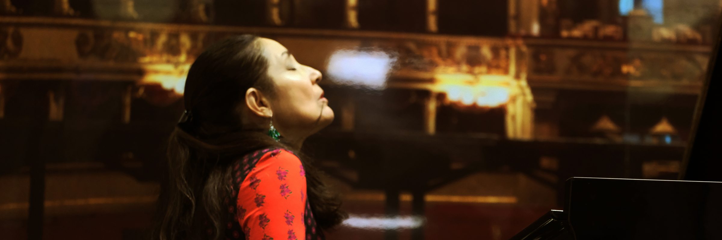Maria Gabriella Mariani al pianoforte in concerto, i palchi del teatro sullo sfondo